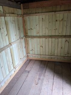 an empty room with wood paneling and wooden floor boards on the walls is seen in this image