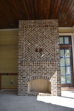 an empty room with a brick fireplace in it