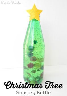 a bottle filled with green liquid sitting on top of a white table next to a yellow star