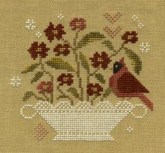 a cross - stitch pattern with a bird and flowers in a white vase on a beige background