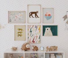 there are many pictures on the wall above the bookshelf in this children's room