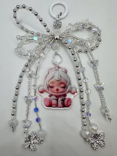 a necklace with an image of a little pig hanging from it's side on a white surface