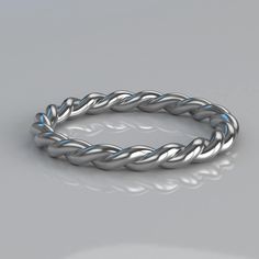 a silver rope ring on a gray surface with reflection in the middle and light reflecting off it's sides