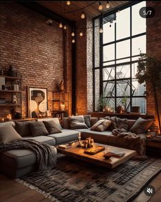 a living room filled with lots of furniture next to a large window and brick wall