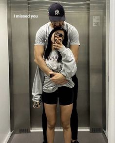 a man and woman taking a selfie in an elevator with their hands on each other's hips