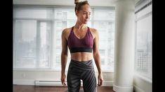 a woman standing in front of a window wearing leggings and sports bra top