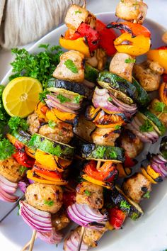 a white plate topped with meat and veggies on top of skewers