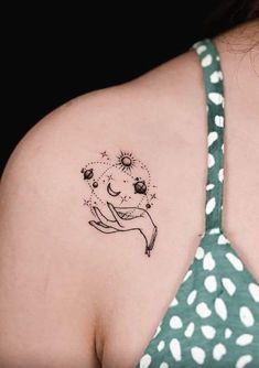 a woman's back shoulder with a tattoo design on the left side of her upper arm