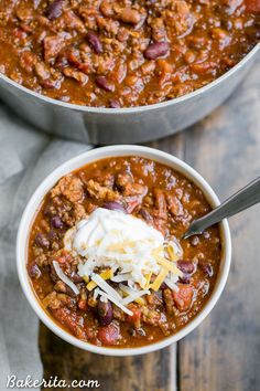 two bowls of chili with cheese and sour cream