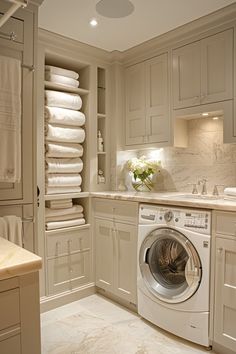 a washer and dryer in a room with white cabinets on either side of it