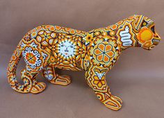 a ceramic animal made to look like a cat with orange and white designs on it's body