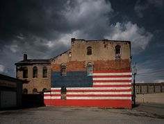 an old building painted in the colors of the american flag is shown against a cloudy sky