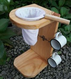 a wooden stand with two coffee cups on it and a cup holder attached to the top