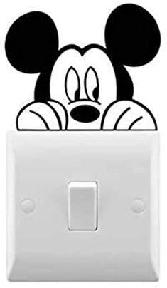 the mickey mouse light switch cover is white and has a black cartoon face on it