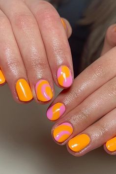 These short, oval-shaped nails are drenched in vibrant shades of summer. The glossy orange base pairs magnificently with playful arcs of pink, creating a delightful contrast that is both eye-catching and cheerful. A perfect blend to brighten up any look with a splash of color! ✨🍊💖  // Photo Credit: Instagram @rmnailtech Nail Orange, Oval Shaped Nails, Orange Nail Designs, Orange Nail