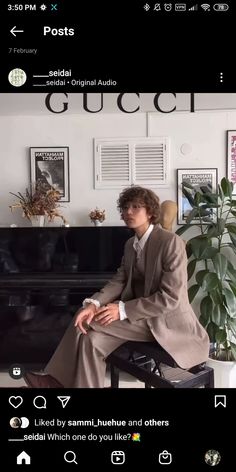 a man sitting in front of a black piano next to a potted green plant