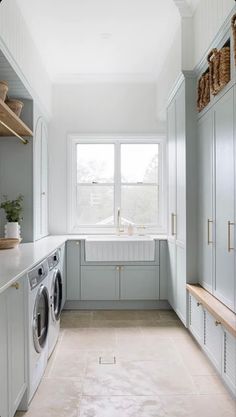 a washer and dryer in a small room with white walls, cabinets and drawers