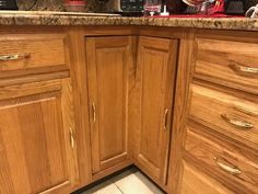 the corner of a kitchen with wooden cabinets and granite counter tops is shown in this image