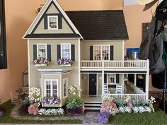 a doll house with flowers in the front yard