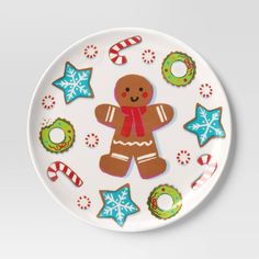 a plate with a gingerbread man and christmas decorations on the front, along with other holiday themed items