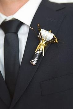 a man wearing a suit and tie with a boutonniere on his lapel