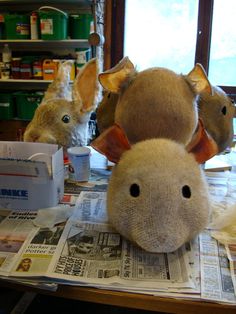 two stuffed animals sitting on top of newspapers