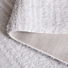 a close up view of a white rug on the floor