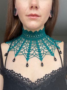 a woman wearing a green crochet choker necklace