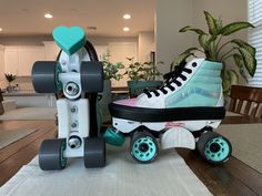 a pair of roller skates sitting on top of a wooden table next to a plant