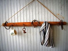 there is a coat rack with keys hanging from it and two mugs on the hooks