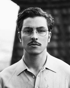 black and white photograph of a man wearing glasses with a moustache on his face