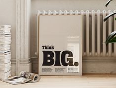 a stack of books sitting on top of a hard wood floor next to a poster