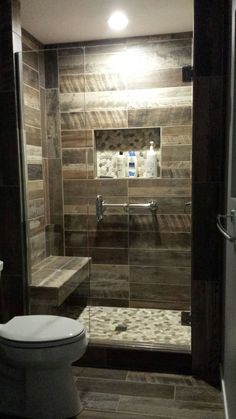 a bathroom with a shower, toilet and sink in it's stall area at night