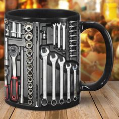 a black coffee mug filled with tools on top of a wooden table