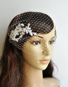 a veiled headpiece with flowers and netting on top, sitting on a mannequin's head