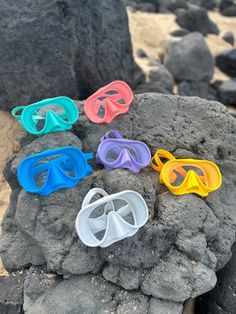 six pairs of goggles sitting on top of a rock