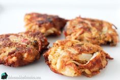 four crab cakes sitting on top of a white plate