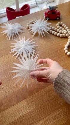 someone is making snowflakes out of white paper