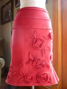 a woman's red skirt with roses on it