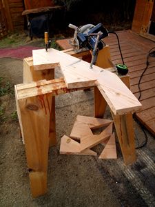 a table made out of wood sitting on top of a wooden deck next to a bike