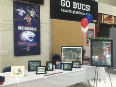 a table with pictures and balloons on it in front of a sign that says go bucs