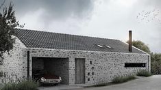 a car is parked in front of a house made out of rocks and stones,