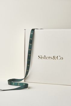 a white box with a blue ribbon on it and the word sister & co printed on it