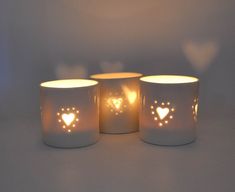 three lit candles with hearts on them sitting next to each other