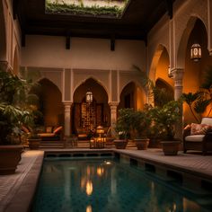 an indoor swimming pool surrounded by potted plants and seating area with chairs around it