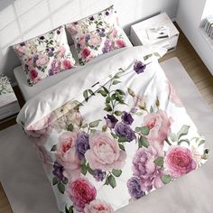 a bed with pink and purple flowers on it