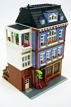 a lego model of a multi - story building with flowers on the windows and balconies