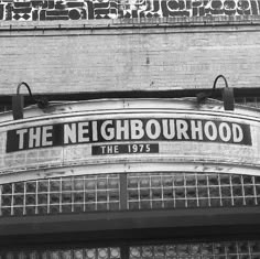 black and white photograph of the neighborhood sign on an old building in new york city