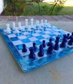 a glass chess board with blue and white pieces