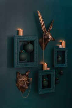 the wall is decorated with candles, ornaments and an animal's head on it